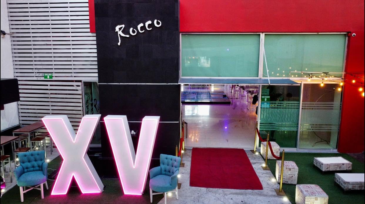 Terraza exterior de Rocco con alfombra roja y letras XV
