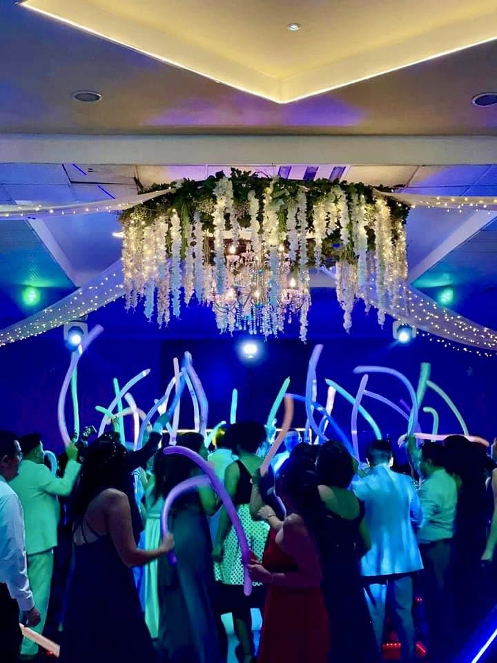 Invitados bailando bajo iluminación azul en la pista