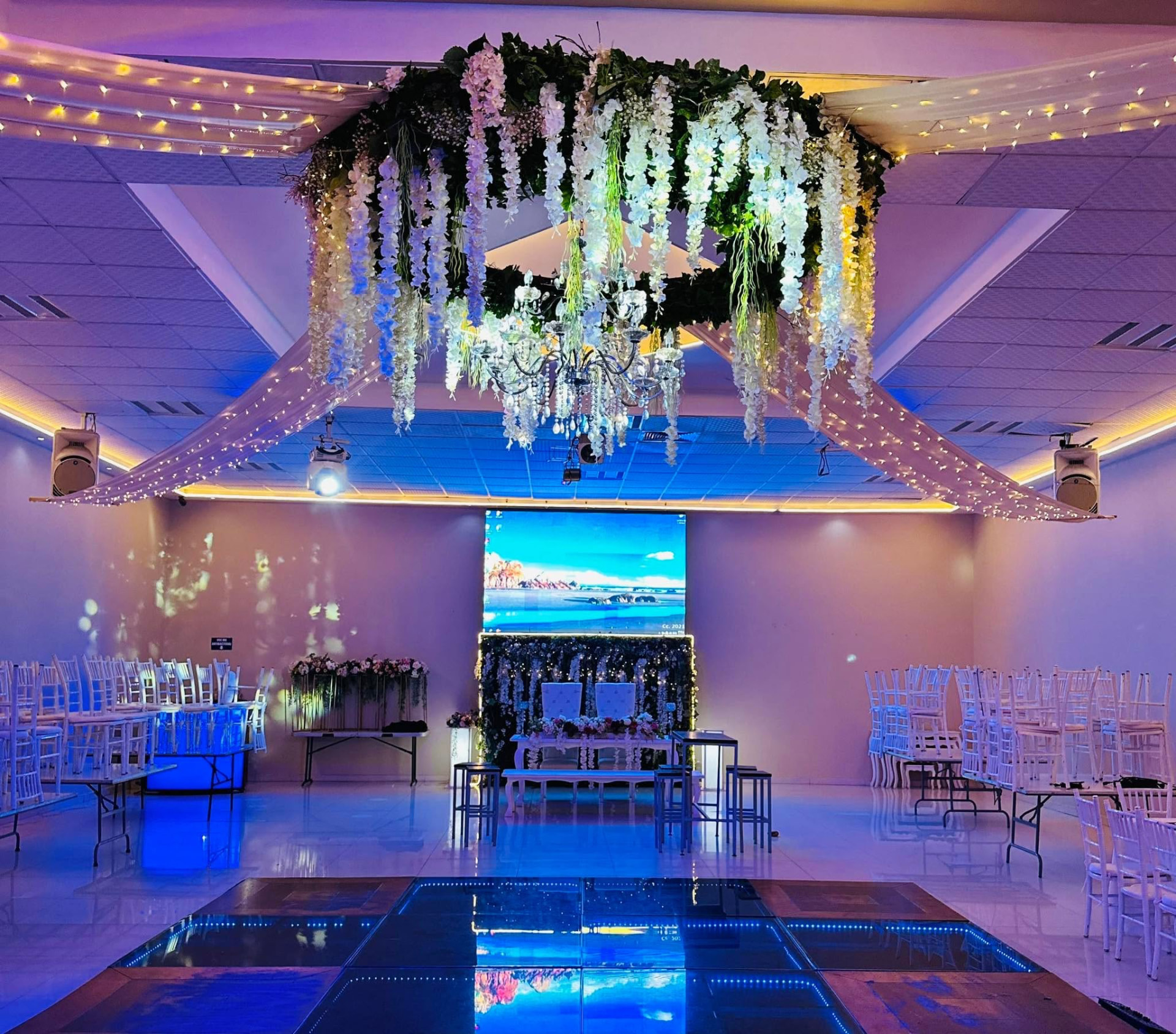 Salón montado con candil floral y pista iluminada